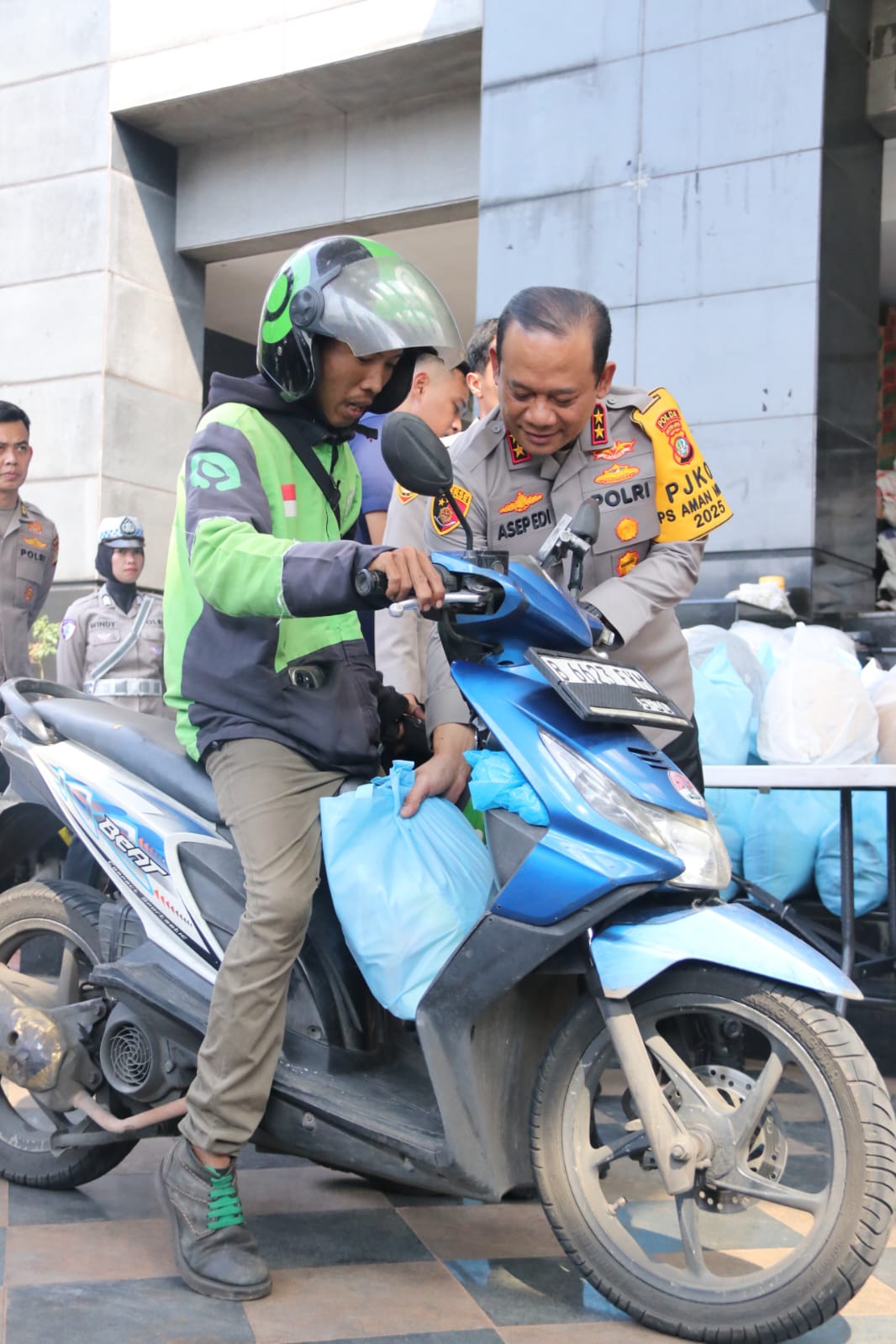Polda Metro Jaya Bagikan Helm dan Sembako untuk Pengemudi Ojek Online